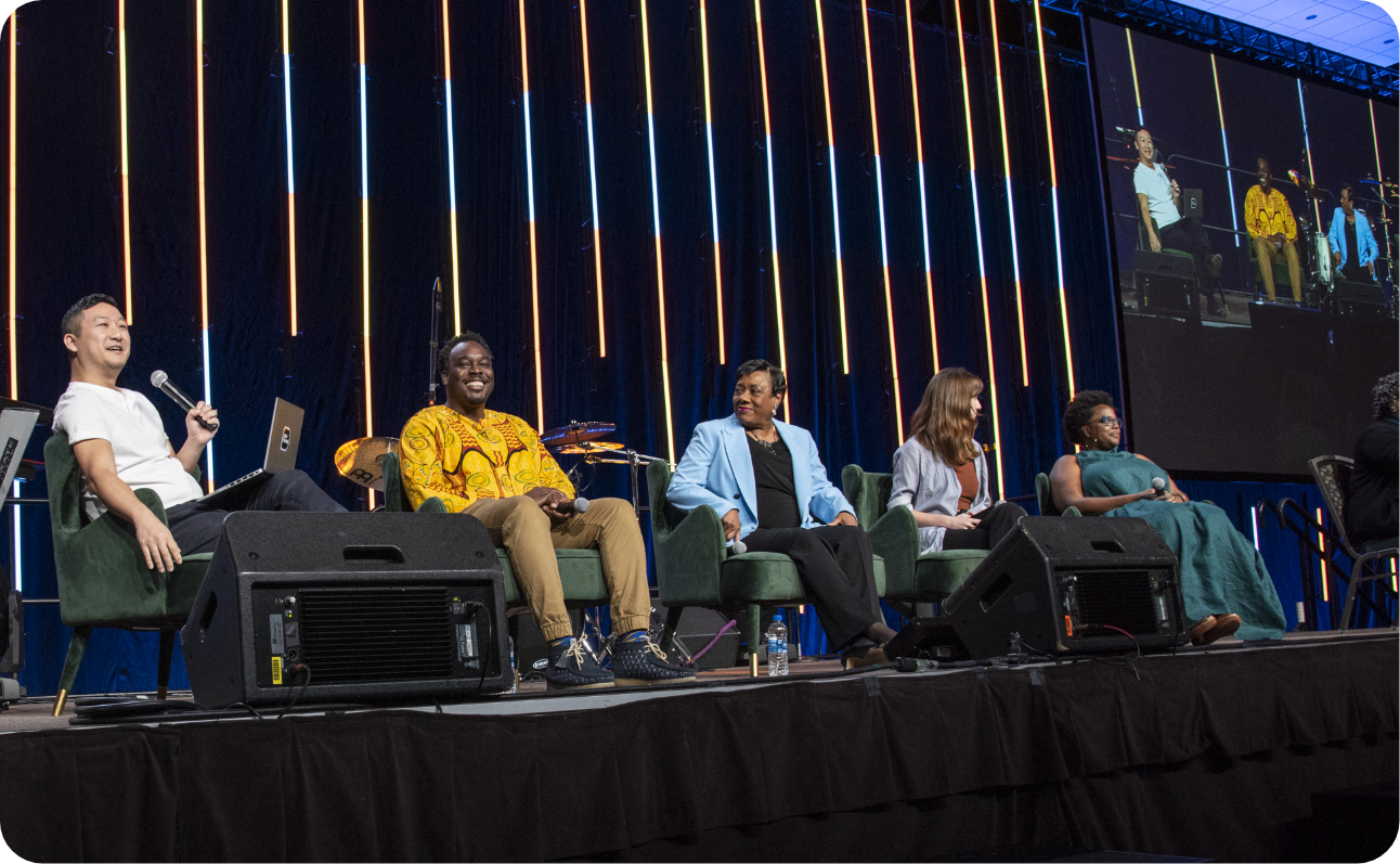panel of people on stage laughing